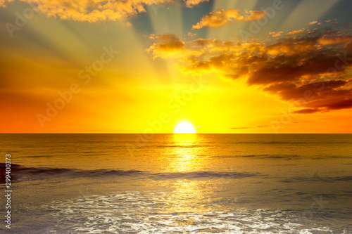 Majestic bright sunrise over ocean and light waves