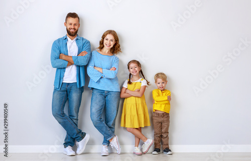 happy family mother father and children daughter and son  near an   grey blank wall.
