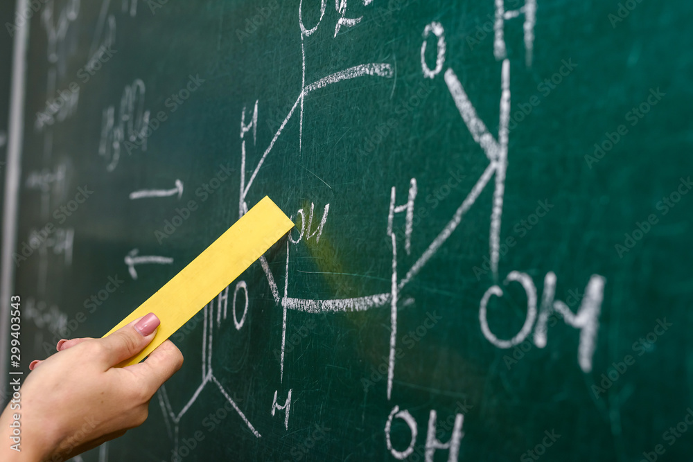 Female hand pointing at chemical formula on blackboard close up Female hand pointing at chemical formula on blackboard close up
