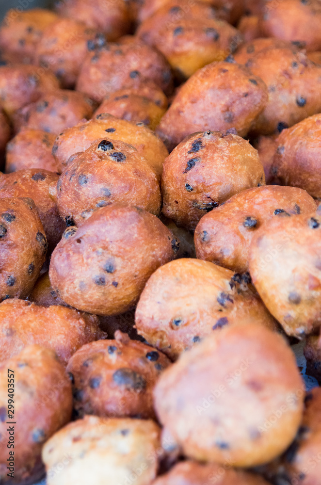 Close up of oliebollen with currants that are baked and stacked Close up of oliebollen with currants that are baked and stacked