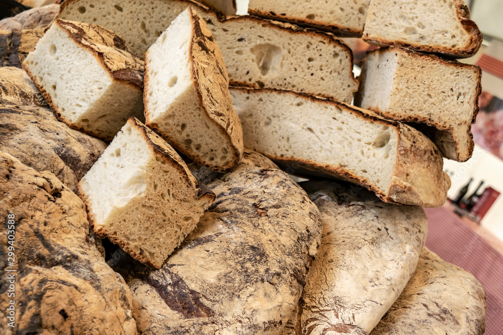Fresh baked bread on a bakery table. Bread and wine in a traditional Mediterranean cuisine. Italian and French authentic loaves of homemade bread. Fresh baked bread on a bakery table. Bread and wine in a traditional Mediterranean cuisine. Italian and French authentic loaves of homemade bread.