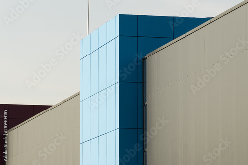 Geometric colored building facade elements with planes, lines and corners with light flare and reflections for an abstract background and texture of white, blue, gray colors. Place for text
