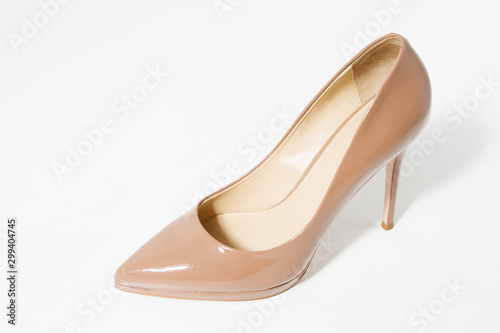 Close up beige high heel women patent leather shoe isolated on white background. Fashion woman shoes accessories. Selective focus. Female shoes on the floor. Copy space. Top view
