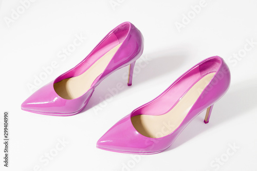 Closeup pink women patent leather shoes isolated on white background. Stilettos shoe type. Summer fashion and shopping concept. Luxury and glamour party ladies wardrobe accessory. Selective focus