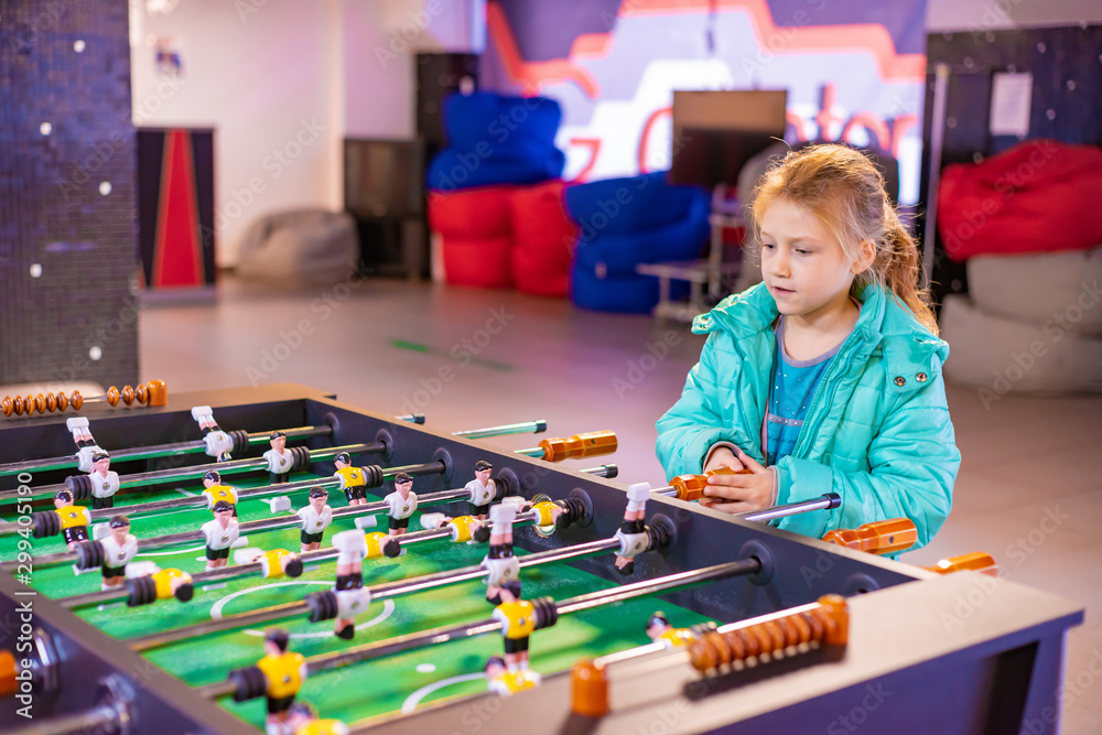 Fototapeta premium Joyful and gambling girl plays table football