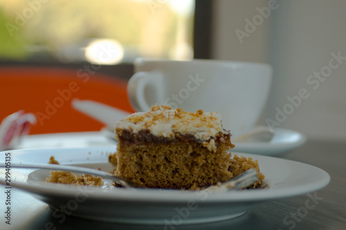  Fresh serving of carrot cake with cup of coffee in background