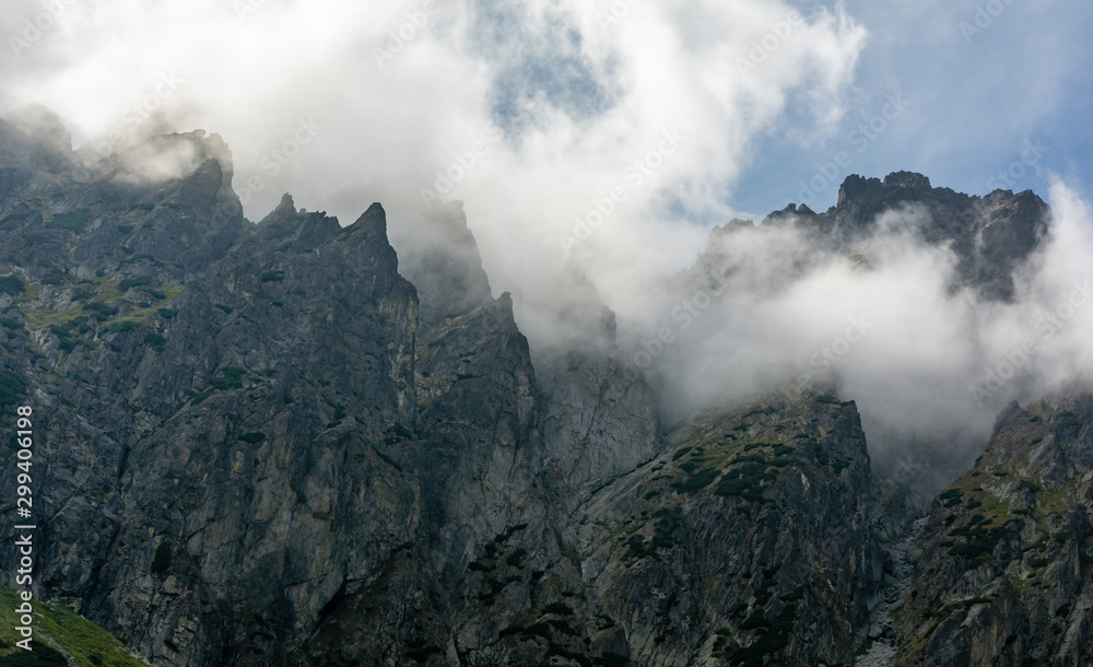 Mountain landscape. Clouds surrounding mountain crags on a rock ridge and gullies. Tatra Mountains.