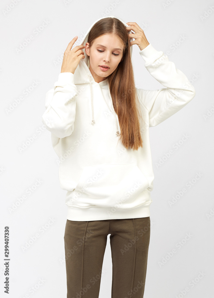 Portrait of young woman wearing grey sportswear sweatshirt hoodie, isolated studio image on white background Portrait of young woman wearing grey sportswear sweatshirt hoodie, isolated studio image on white background