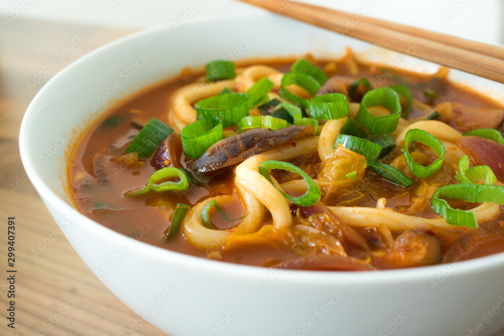 Food photography of a spicy Korean Asian noodle soup in a white bowl. Food photography of a spicy Korean Asian noodle soup in a white bowl.