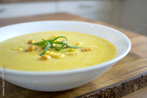 Food photography of a creamy corn soup in a white bowl.