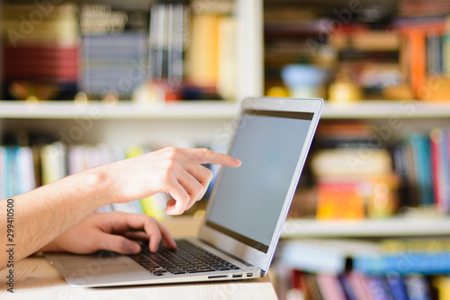 Close up hands multitasking man using notebook computer in library