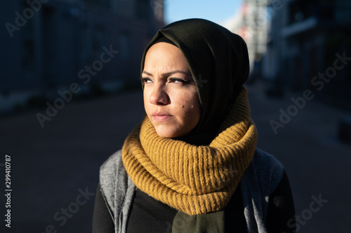 Portrait of a young woman wearing headscarf looking toward sunshine