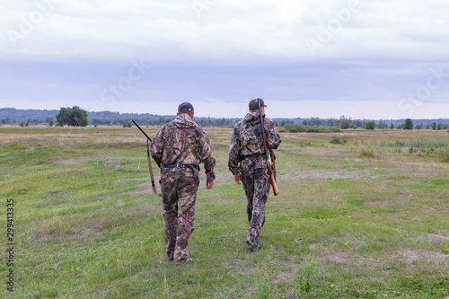 Hunters men with weapons go hunting