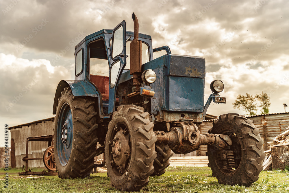 An old wheeled tractor stands on an open-air farm An old wheeled tractor stands on an open-air farm
