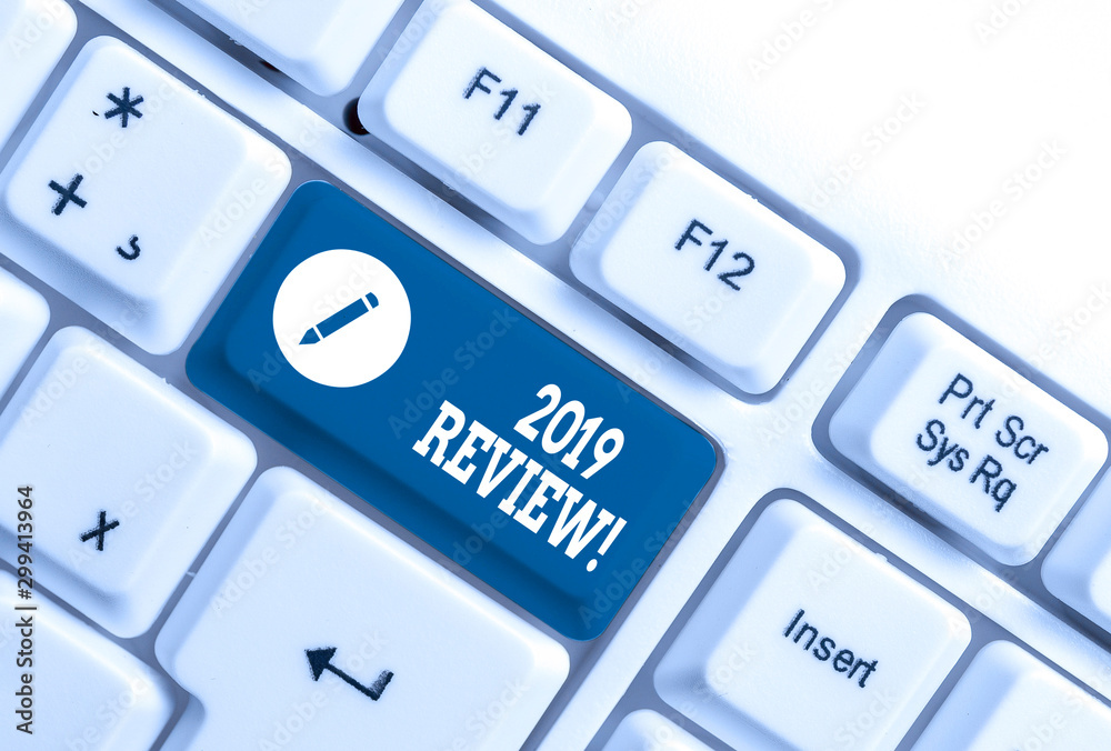 Conceptual hand writing showing 2019 Review. Concept meaning remembering past year events main actions or good shows White pc keyboard with note paper above the white background Conceptual hand writing showing 2019 Review. Concept meaning remembering past year events main actions or good shows White pc keyboard with note paper above the white background