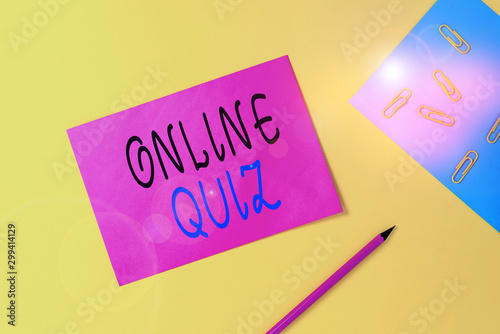 Writing note showing Online Quiz. Business concept for game or a mind sport that are published on the Internet Blank paper sheets message pencil clips binder plain colored background