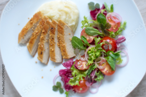 Food photography of a contemporary dish with white meat, parsnip mash and a side salad