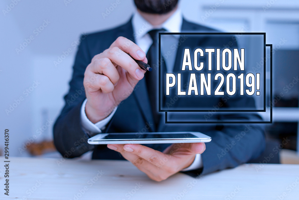 Conceptual hand writing showing Action Plan 2019. Concept meaning proposed strategy or course of actions for current year Male human wear formal clothes present use hitech smartphone Conceptual hand writing showing Action Plan 2019. Concept meaning proposed strategy or course of actions for current year Male human wear formal clothes present use hitech smartphone