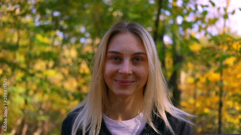 Portrait of pretty blonde woman on nature, young happy girl smiling at camera in autumn park Portrait of pretty blonde woman on nature, young happy girl smiling at camera in autumn park