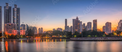 Lake in City Park under Skyscrapers at Twilight. Benjakiti Park in Bangkok, Thailand