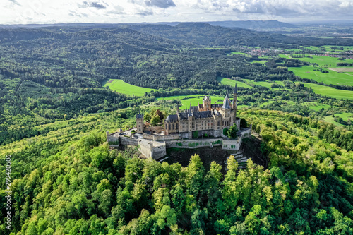 Aerial panorama of Burg Hohenzollern (Hohenzollern castle) with hills and villages surrounded by forests with beautiful foliage