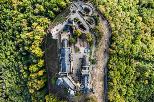 Aerial panorama of Burg Hohenzollern (Hohenzollern castle) with hills and villages surrounded by forests with beautiful foliage