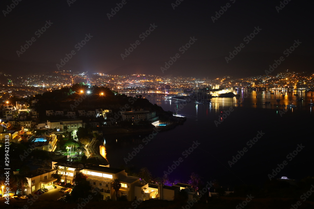 View from the hill to the colorful panorama of the night Bodrum mountains Marina attractions Turkey.Multi-colored neon lights,lamps,lights, night resort.Reflection in water Background Wallpaper