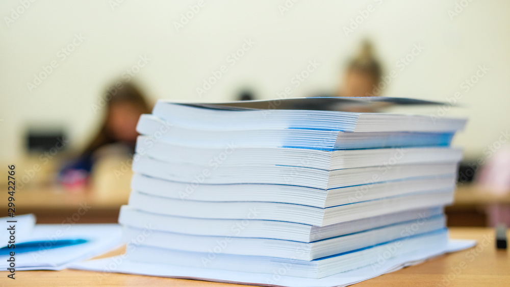 image of a stack of notebooks on the teacher's desk image of a stack of notebooks on the teacher's desk