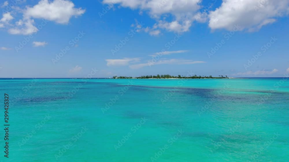 Aerial: Gliding Across Beautiful Tropical Water Towards Deserted Island on a Sunny Day - Nassau, Bahamas Aerial: Gliding Across Beautiful Tropical Water Towards Deserted Island on a Sunny Day - Nassau, Bahamas