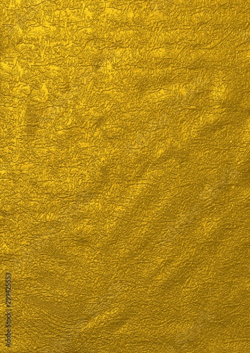gold bumpy grungy rough metallic surface with golden paint strokes and foil texture for abstract surface designs and backgrounds. 