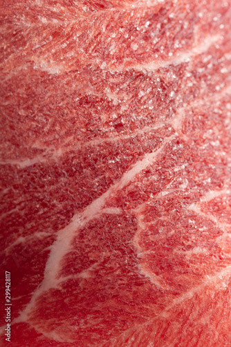 Texture of frozen fresh raw meat, close up, macro. Vertical frame.