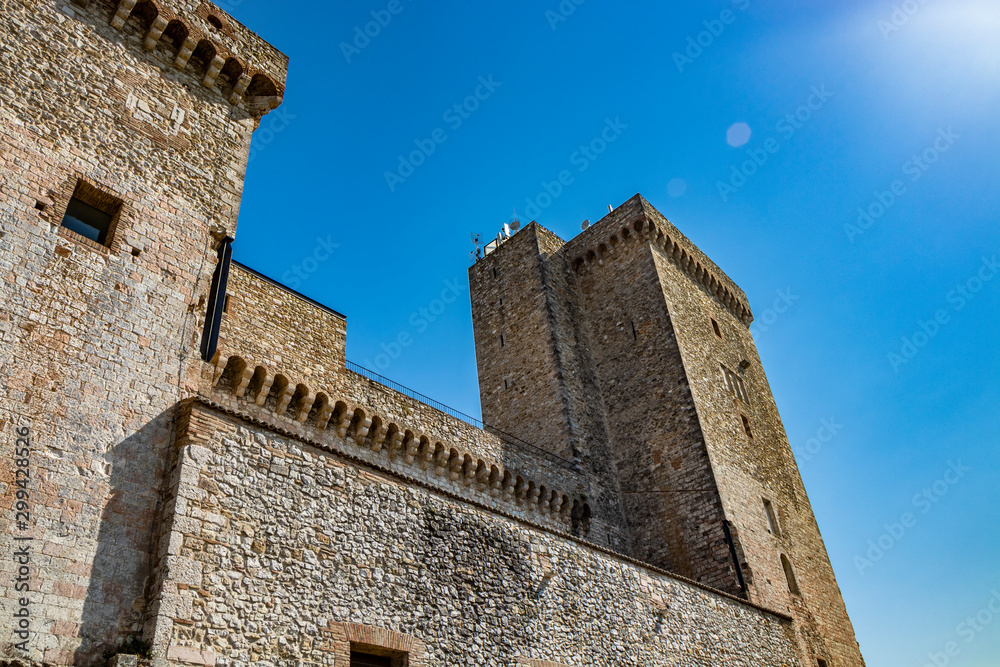 Il castello medievale dell'antico borgo di Narni. Umbria, Terni, Italia. I muri di pietra e le torri della fortezza. Il cielo azzurro d'estate. The sun flare and glow.
