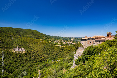 A characteristic glimpse of the ancient medieval village of Narni. Umbria  Terni  Italy. The blue sky on a summer day. The valley below with the green hills. The Benedictine Abbey of San Cassiano.