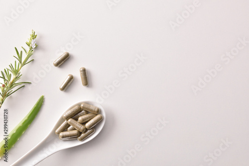 Background with capsules of natural medicine with pants white table photo