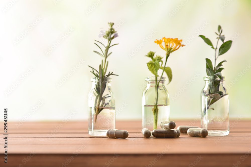 Natural herbal medicine capsules on wooden table with tree jars - obrazy, fototapety, plakaty 