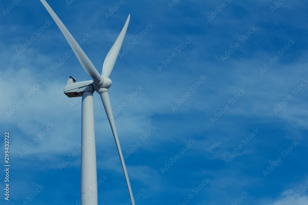 Close upward view of a giant wind power turbine propeller with a blue sky background Close upward view of a giant wind power turbine propeller with a blue sky background