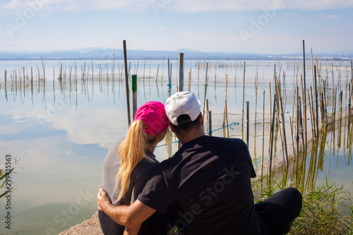 Pareja de enamorados mirando el horizonte de forma romántica en el lago la Albufera  photo