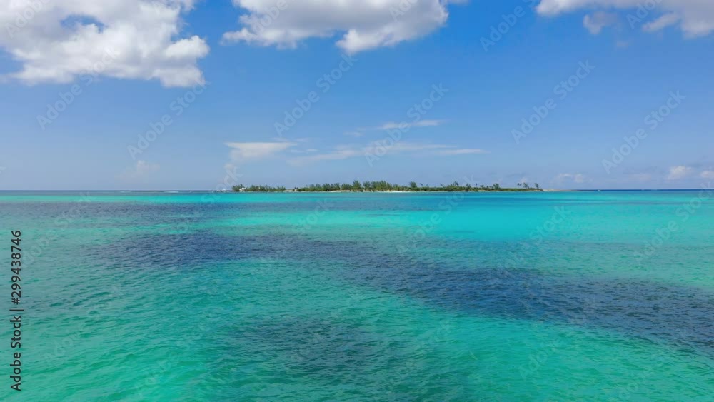 Aerial: Gliding Across Serene Tropical Water Towards Deserted Island on a Sunny Day - Nassau, Bahamas Aerial: Gliding Across Serene Tropical Water Towards Deserted Island on a Sunny Day - Nassau, Bahamas