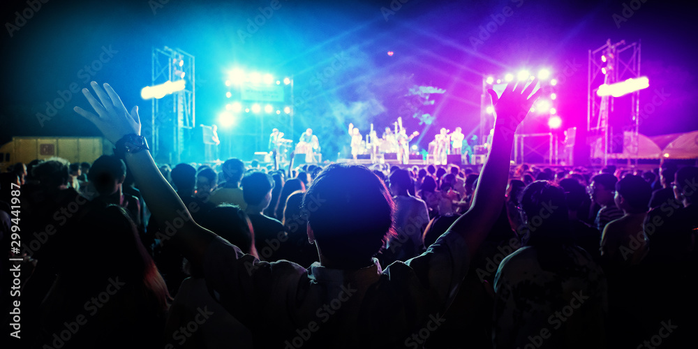 silhouettes of people in concert in front of bright stage lights