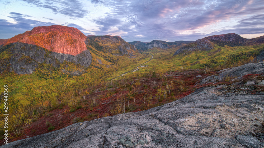 Red dawn over the hills and cliffs around the valley at Fall, Quebec, Canada