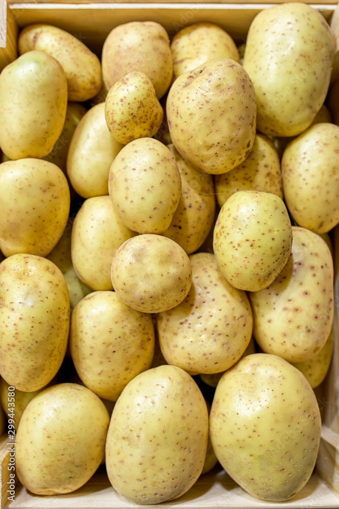 fresh potatoes in wooden box on wooden table, top view fresh potatoes in wooden box on wooden table, top view