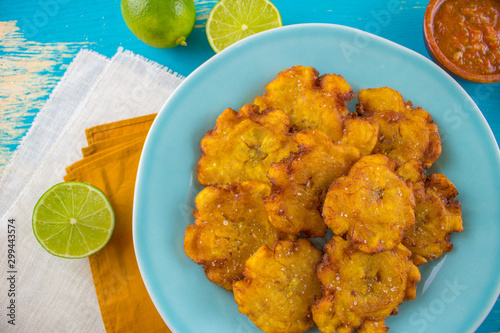 Food photography of latin american tostones or patacones on a blue background photo