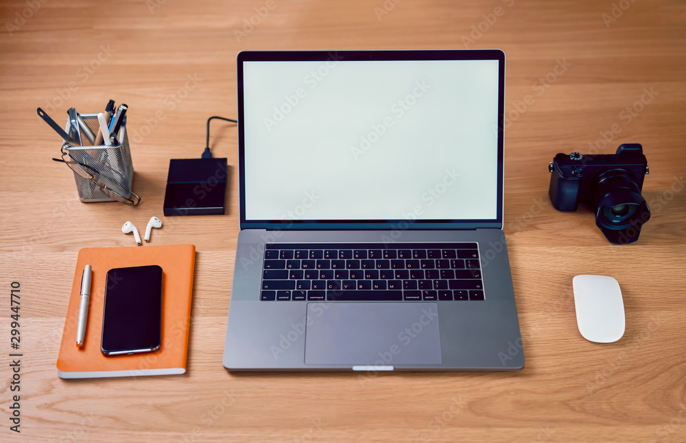 Laptop computer and smartphone in creative office, blank screen on mockup for design advertising. Laptop computer and smartphone in creative office, blank screen on mockup for design advertising.