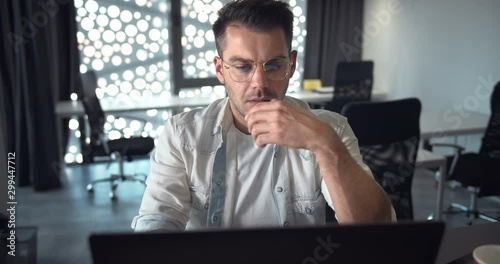 Exhausted male office worker browsing internet searching for information, deadline stress
