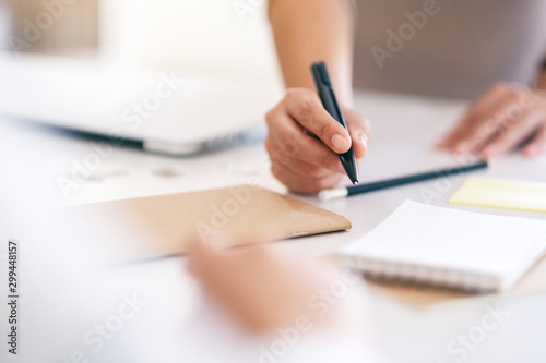 Group of businessman discussing and writing on notebook on the table in office