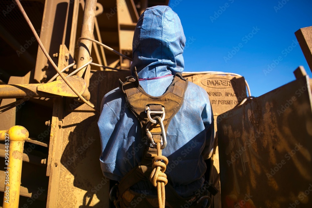Rope access miner wearing safety harness connecting into Karabiner