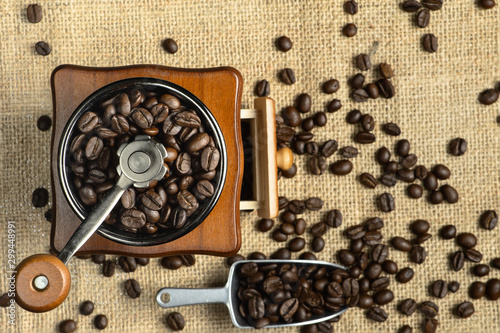 beverage background of roasted coffee bean in coffee grinder and in scoop and on gunny cloth background
