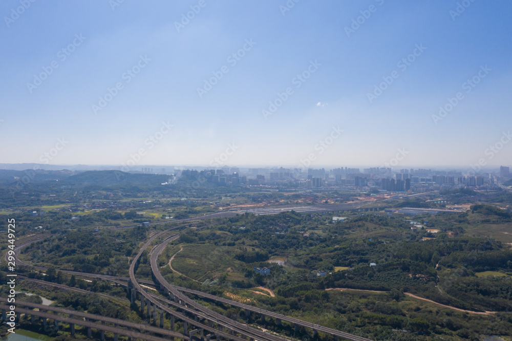 Aerial shot of curved railway ground and sky landscape over city suburbs