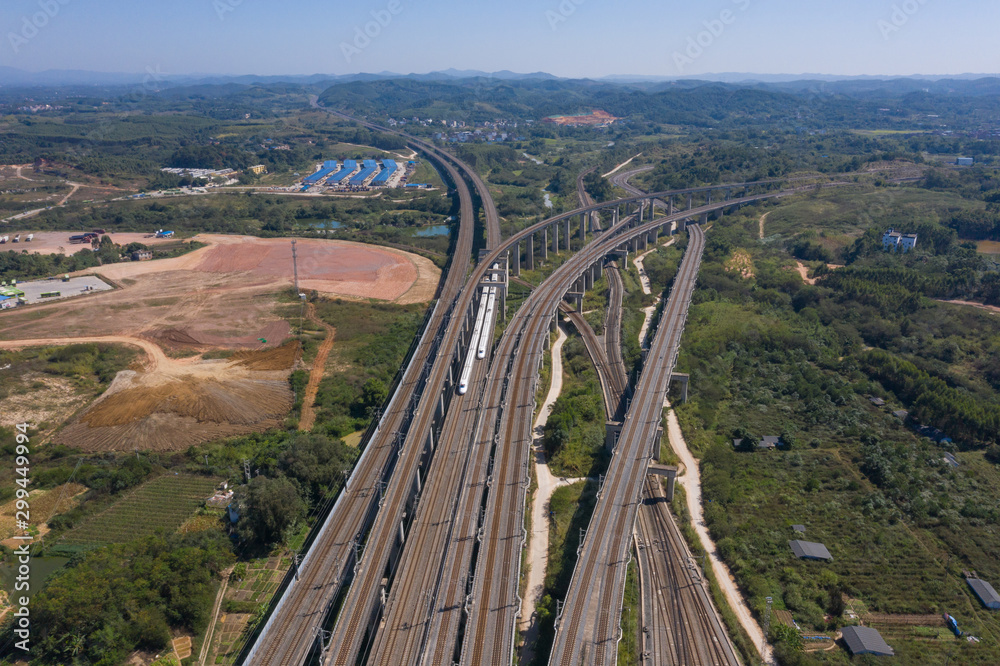 Aerial shot of 2 high-speed trains driving on dense railways