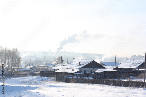 village in winter landscape, roof pipes with smoke